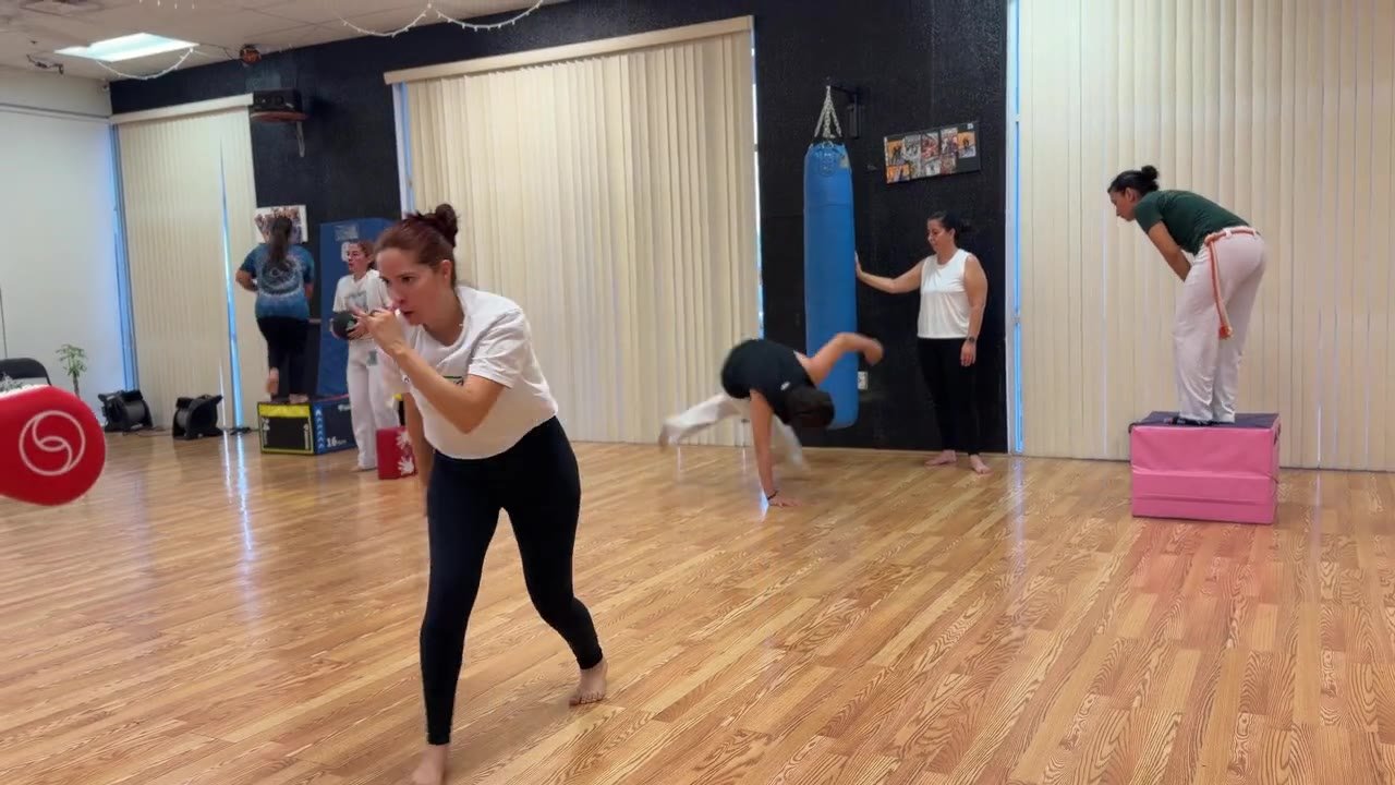 A young student kicking the pad, handstands behind